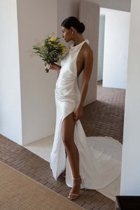 Dress Goldie is the perfect choice for modern brides. Featuring a stunning halter neckline and sleeveless design, this simple mermaid wedding dress is made of high-quality satin material and boasts an open back and high side slit for added elegance. With its floor length, it's sure to make a lasting impression on your special day.