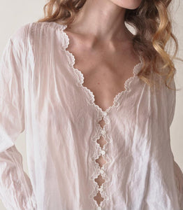 Introducing the Elayne Top from Doen, made from the softest organic cotton voile. This fan-favorite style features a plunging V-neck, double scallop sleeves, and an adjustable back waist tie for the perfect fit. Playful cutouts and mother-of-pearl buttons add a touch of whimsy, while pintucks create texture and dimension. Look and feel effortlessly beautiful in this must-have top.