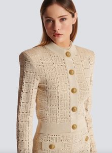 Elevate your style with Ensemble Vera! Featuring a chic openwork embossed pattern, gold buckle, and slim standing collar, this long-sleeved cardigan top is a must-have addition to your wardrobe. Perfect for layering or wearing on its own, it's a versatile piece that adds sophistication to any outfit. (You'll be the envy of everyone!)