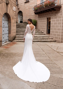 Introducing the Robe Kiara - a vintage mermaid wedding dress fit for a regal bride. With its long lace sleeves and seductive open back, this dress exudes elegance and femininity. The intricate applique detailing adds a touch of luxury, making you the center of attention on your special day.