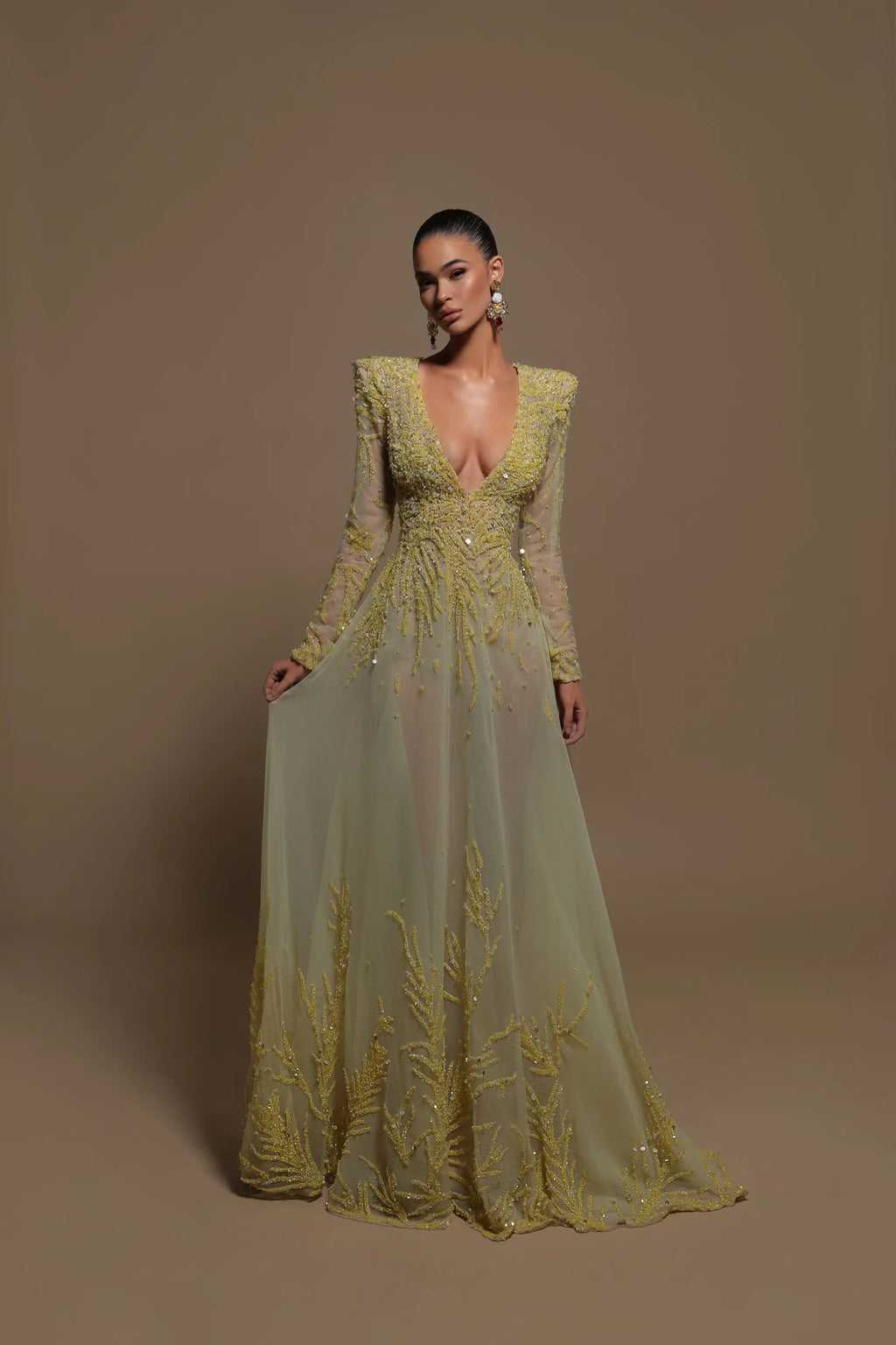 Expertly crafted, the Manette Gown combines a V-neckline and long sleeves with embellished details and shoulder pads. Making a timeless statement, this evening dress effortlessly flatters your figure and exudes elegance. Elevate your look with this stylish and sophisticated piece.