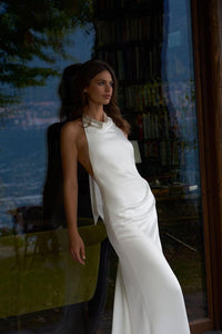 Dress Goldie is the perfect choice for modern brides. Featuring a stunning halter neckline and sleeveless design, this simple mermaid wedding dress is made of high-quality satin material and boasts an open back and high side slit for added elegance. With its floor length, it's sure to make a lasting impression on your special day.