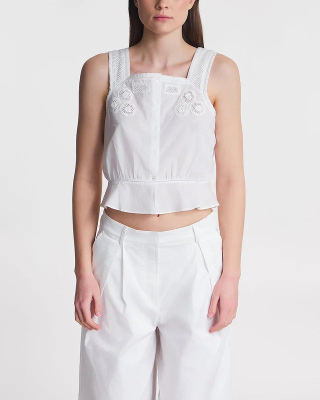 Indulge in the elegant and sustainable Top Kirsten. This cropped top features delicate lace details and a front buttoning design, crafted with soft organic cotton. Its wide shoulder straps and straight neckline create a flattering fit. Perfect for the conscious fashionista.