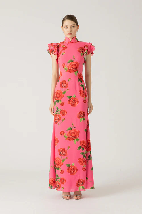 Effortlessly make a statement in the stunning Sylvie Floral Dress. This SAU LEE original features a vibrant rose print on stretch fabric, complete with a signature Mandarin collar and decorative frog buttons. The layered ruffle sleeves and full-length trumpet skirt add a touch of femininity to this must-have maxi.