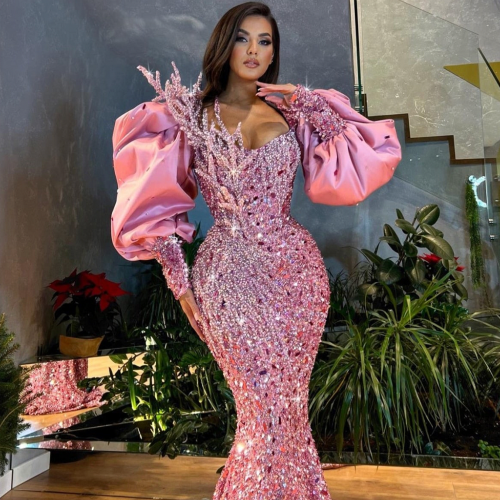 Our Robe Galene is the perfect dress for standing out! Its shining pink siren-style and bejeweled with rhinestones and sequins will have you looking exquisite for any special occasion. Puffy sleeves add the perfect finishing touch! Sparkle your way into the night!