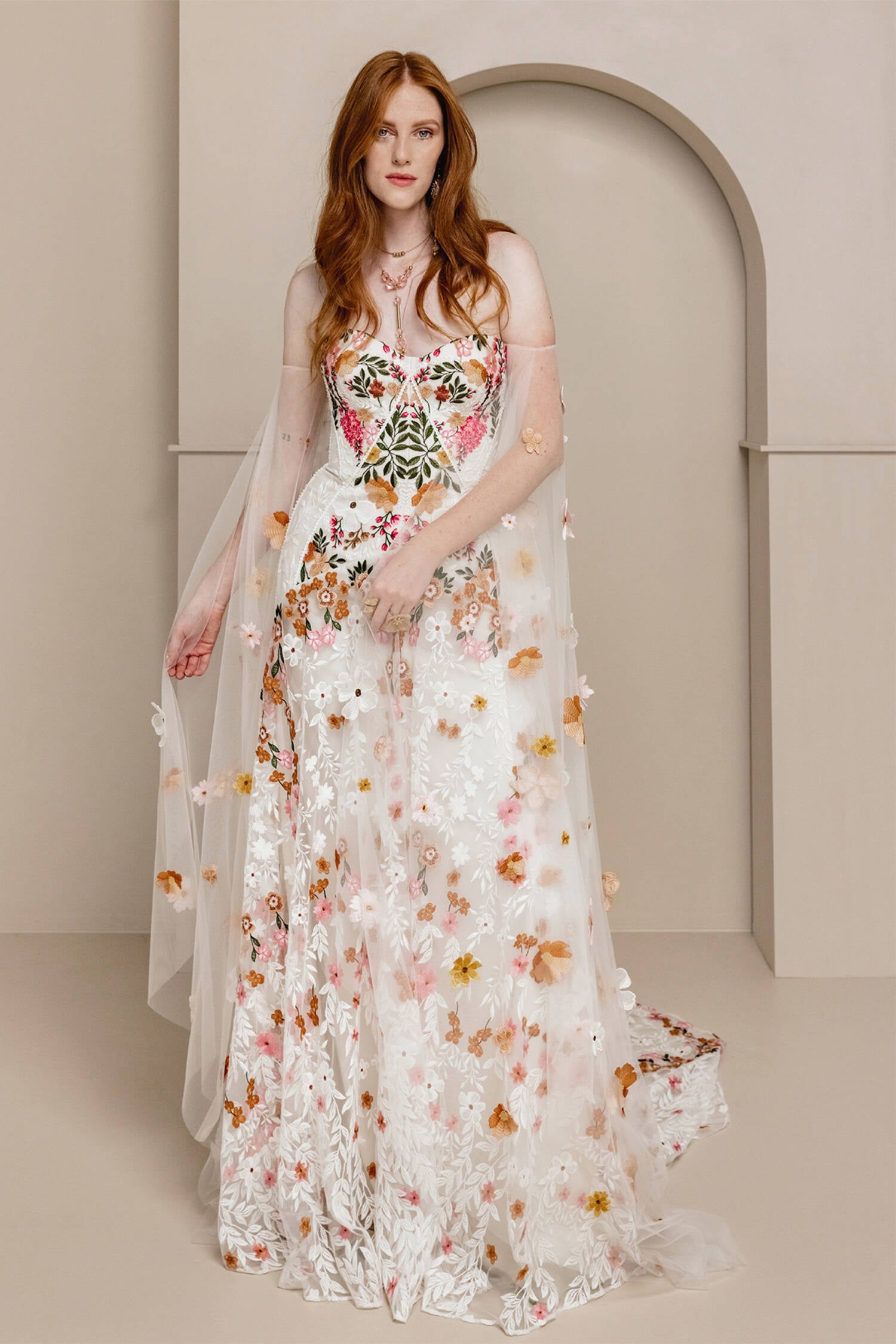 Introducing Meadow Gown - a work of art inspired by desert blooms. Its vibrant florals are delicately embroidered on sand-dyed tulle, creating a stunning contrast against bare terrain. With a fully boned bodice for support and a dramatic train with cascading flowers, this gown exudes a playful yet sophisticated charm. Perfect for the bold bride looking to infuse color into her special day.