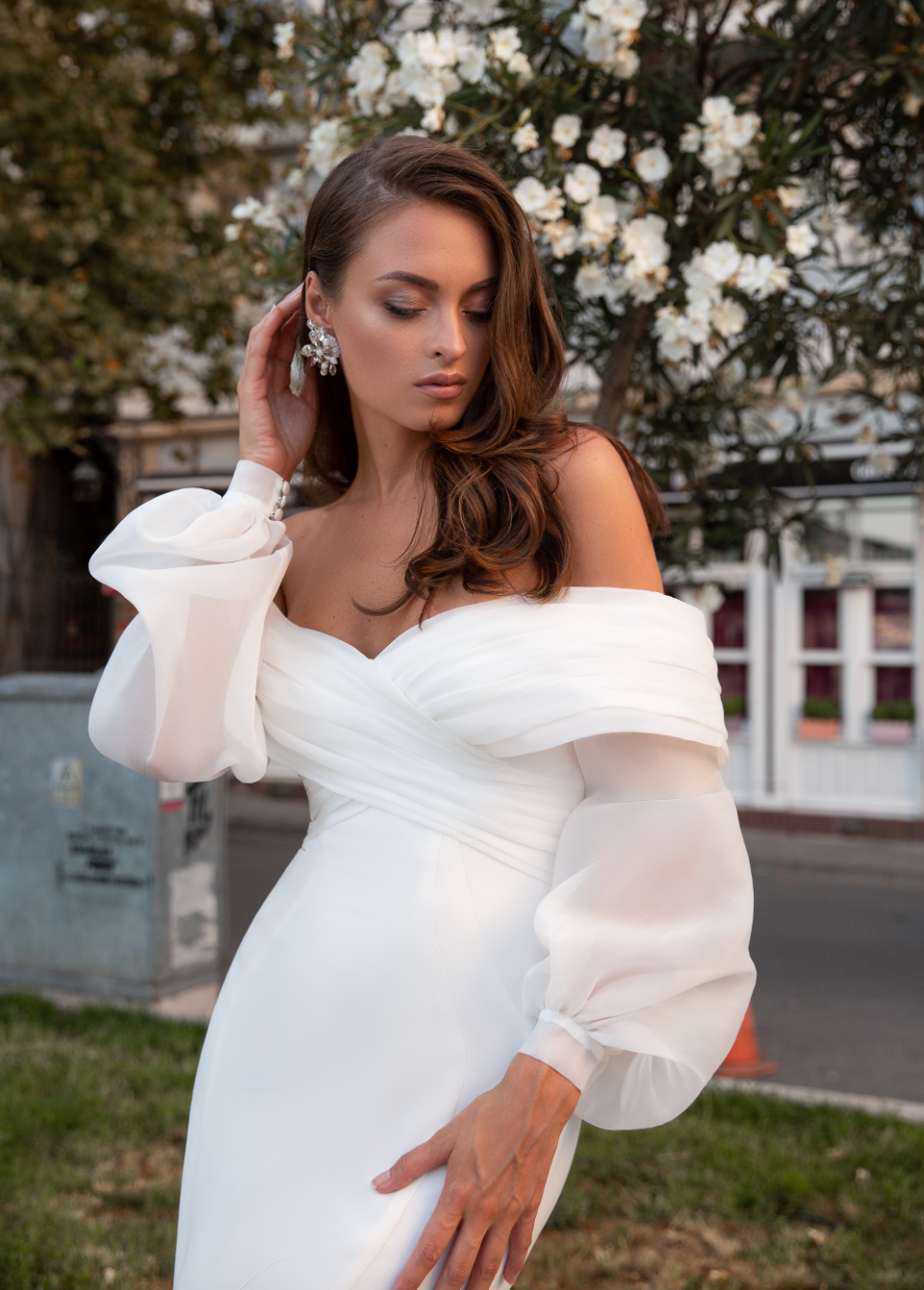 Experience pure elegance with Robe Alora! This bohemian-inspired wedding dress features a sexy satin mermaid silhouette, long lace sleeves, and sultry off-the-shoulder detailing for a ravishing and timeless look. Get ready to turn heads on your special day!