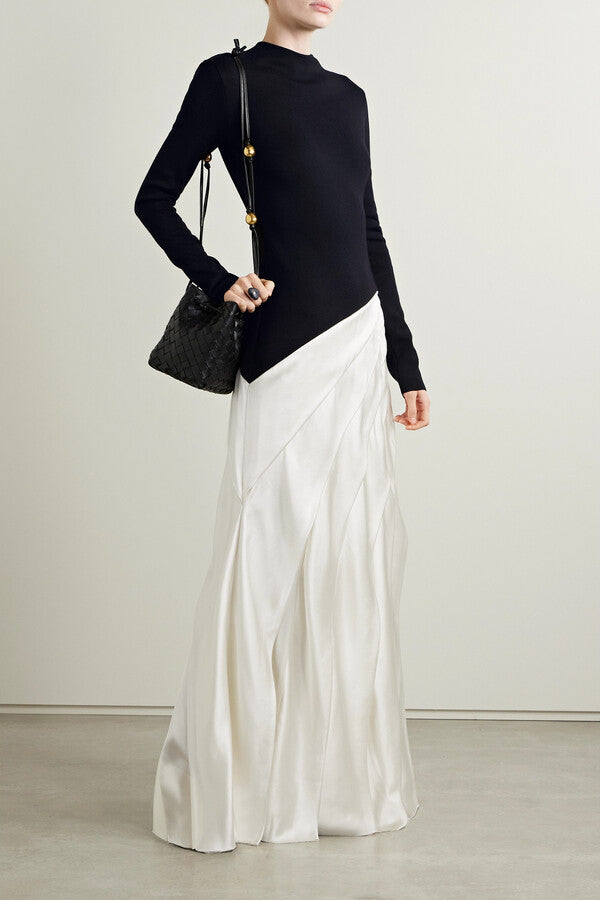 Indulge in luxury with the Ismay Silk Pleated Maxi Dress by Gabriela Hearst. This elegantly crafted piece boasts a clever design, featuring a black silk knitted bodice and a white pleated satin skirt for a striking contrast. The sharp pleats create beautiful movement as you walk, while the mock neckline adds a touch of sophistication. Perfectly paired with classic pumps for a timeless look.