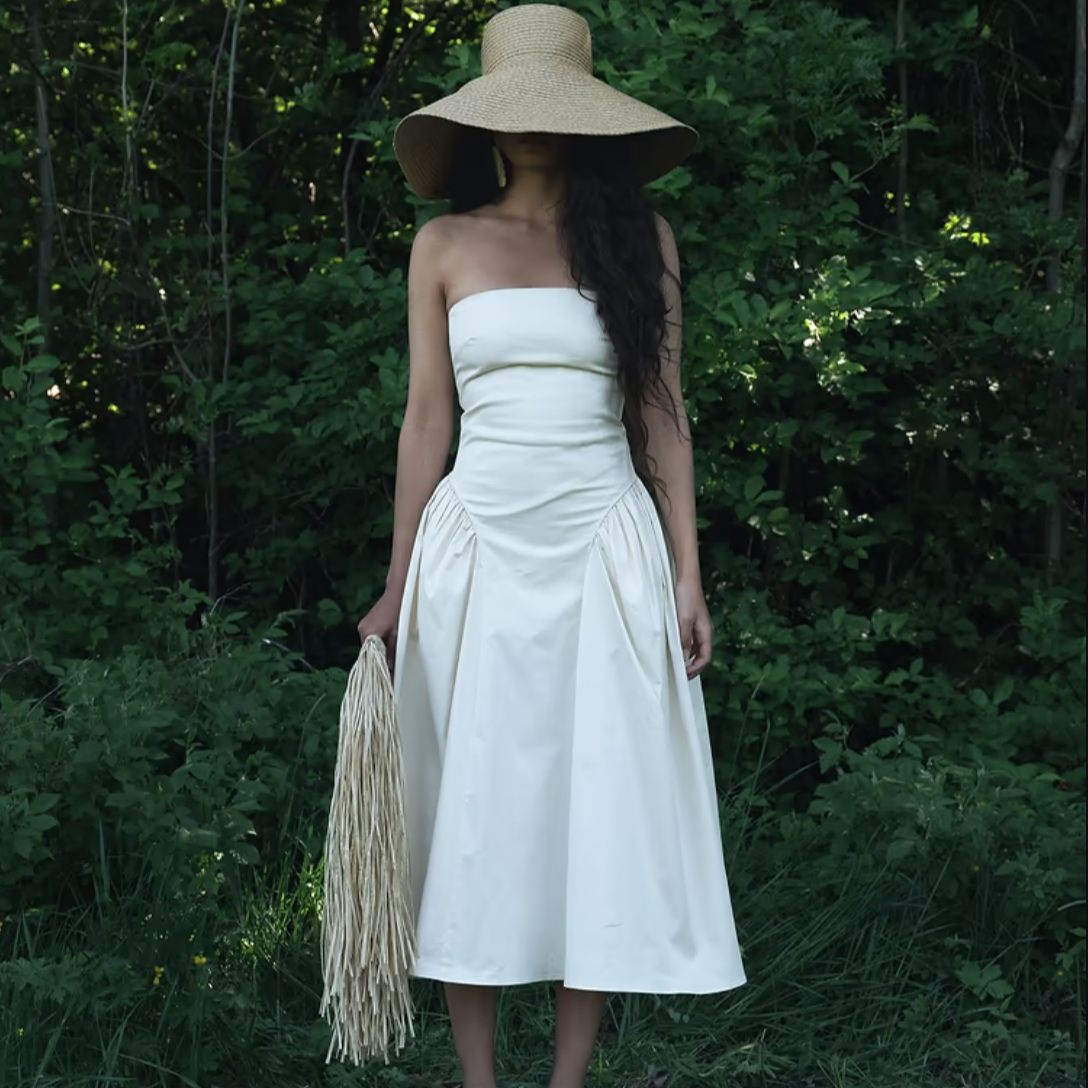 Introducing our Lily Dress, crafted with soft, breathable cotton for ultimate comfort. This strapless dress boasts a fitted bodice that accentuates your figure and transitions into a gathered hip, mid-length skirt. Its bold minimalist design highlights your natural curves, making it the perfect choice for dreamy summer days.