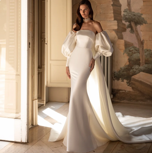 Introducing Dress Myla - the epitome of elegance and sophistication. This wedding dress features a trumpet silhouette and a strapless design, exuding a timeless charm. The elegant puff sleeves add a touch of luxury and romance, making it the perfect choice for any bride on her special day.