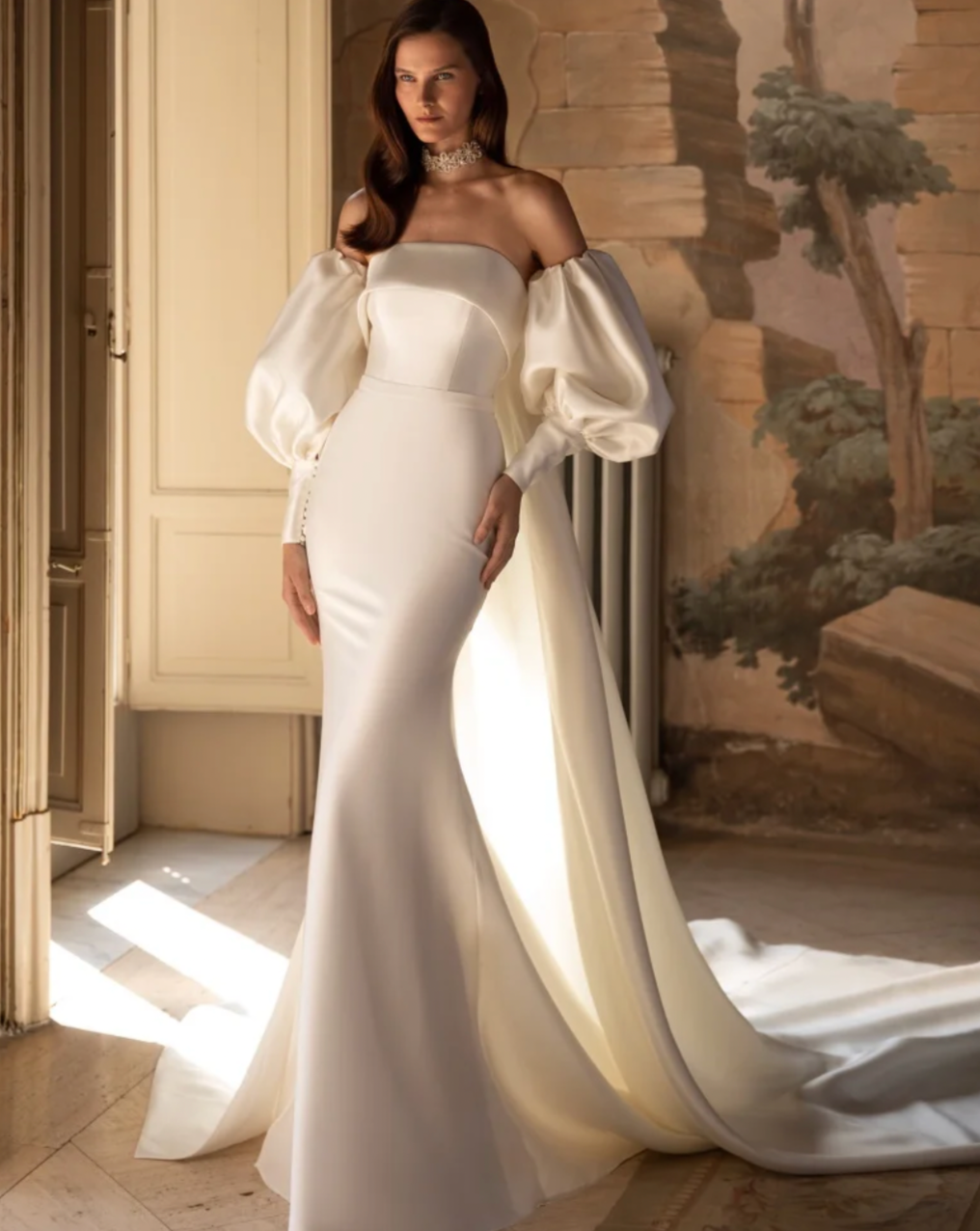 Introducing Dress Myla - the epitome of elegance and sophistication. This wedding dress features a trumpet silhouette and a strapless design, exuding a timeless charm. The elegant puff sleeves add a touch of luxury and romance, making it the perfect choice for any bride on her special day.