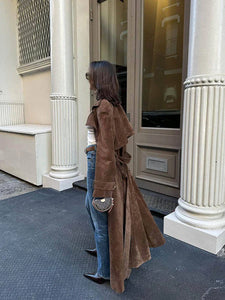 Elevate your style with the Corrin Suede Trench Coat by Ducie. Crafted from luxurious suede leather, this double breasted trench is complete with a storm flap and leather sash for a sophisticated touch. Its cocooning design and satin lining make it a timeless addition to your wardrobe.