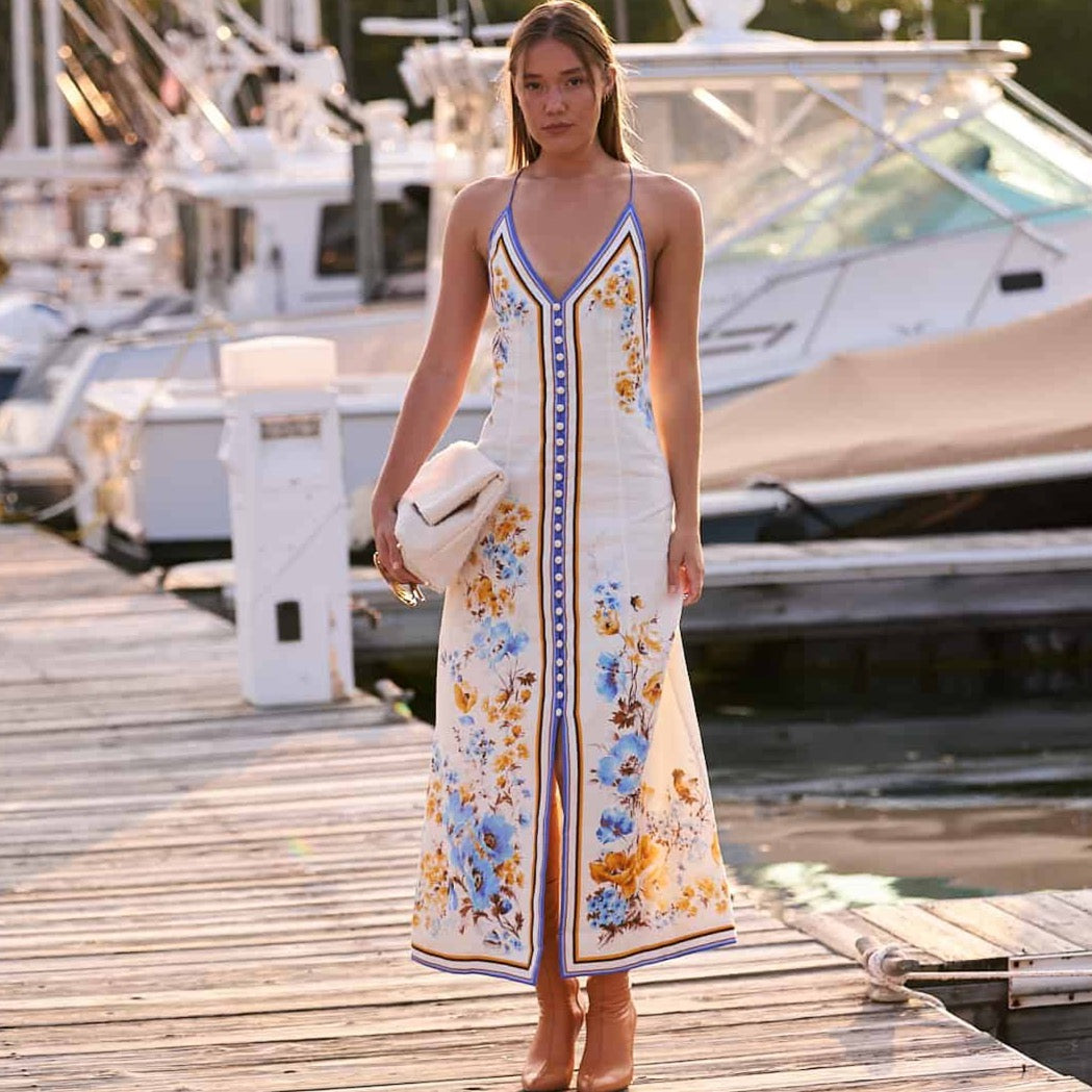 The Emy Midi Dress showcases whimsical, iconic floral prints that add a touch of playfulness to any wardrobe. Crafted from lightweight linen, this dress features a buttoned front placket and crossover shoulder straps for a sophisticated yet comfortable look. Elevate your style with this chic and versatile piece.