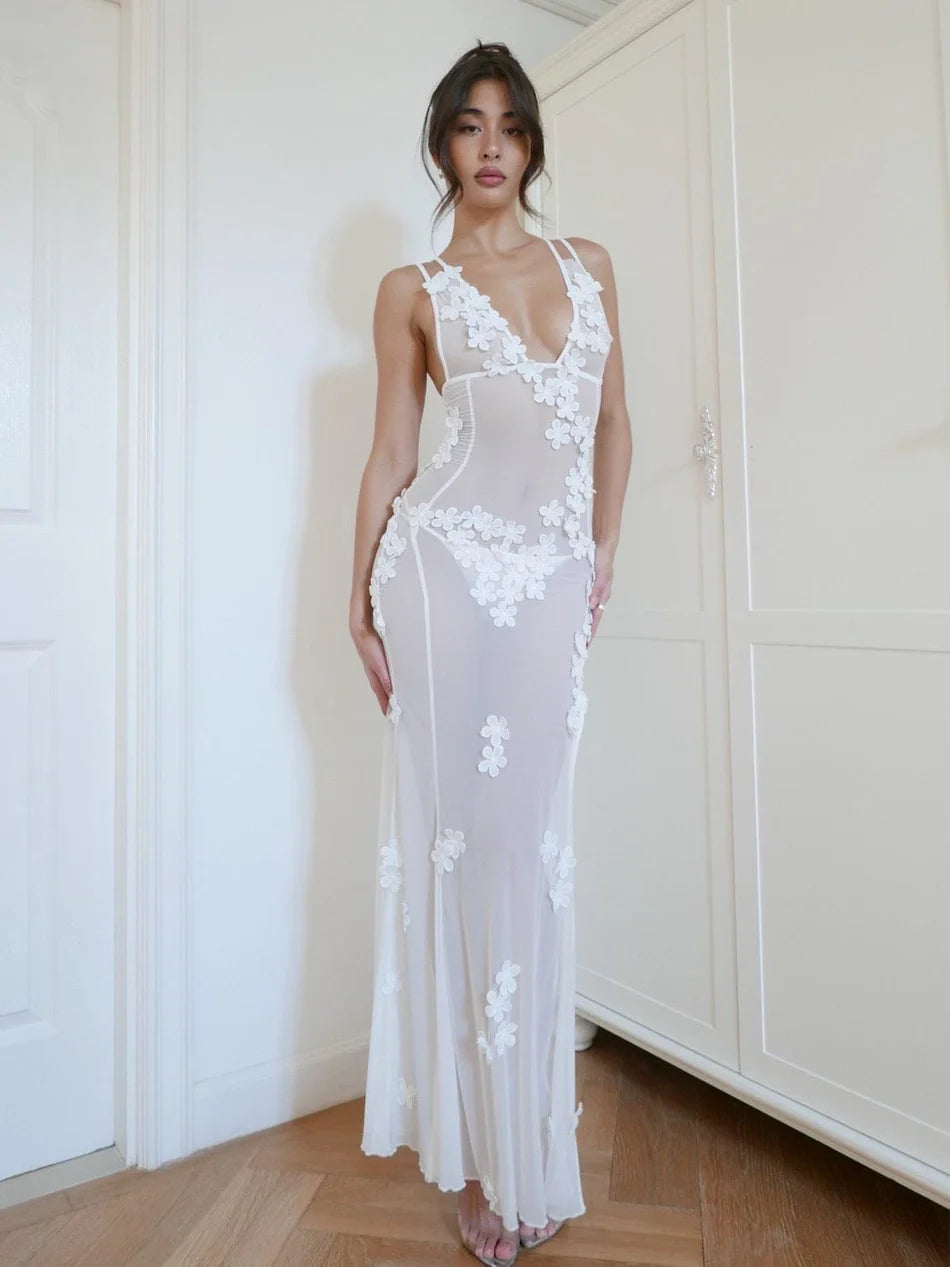 Indulge in luxury with the Marcia Dress. Hand-finished by skilled artisans, this fairy dress boasts 3-D flowers and a mesh fabric for a flawless fit. The low neck, high slits, and double straps create an elegant hourglass silhouette, perfect for a cover-up, maxi dress, or beach wedding attire.