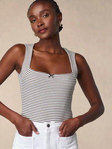 Enhance your wardrobe with the sophisticated Ilonka Top. This luxurious t-shirt features a unique trapeze neckline, adorned with a black satin bow for a touch of elegance. The black and white sailor print adds a touch of nautical charm, making this top a must-have for any fashion-forward individual. Plus, the mini ribbed jersey fabric ensures a comfortable and flattering fit. Elevate your style with Ilonka.