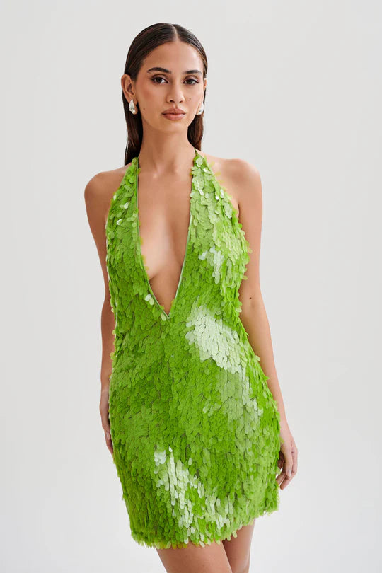 Make a statement with the dazzling Sequin Halter Mini Dress. The plunging halter neckline and shimmering sequins will turn heads at any party or special event. The fitted silhouette and mini length accentuate your curves, while the vibrant parakeet green color adds a touch of glamour. Elevate your wardrobe with this must-have dress that exudes sophistication and elegance.