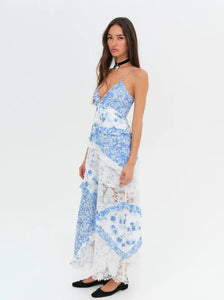 Introducing the luxurious Rosalyn Dress from For Love and Lemons, back in a stunning blue floral print. Inspired by '70s fashion, this maxi dress features mixed print paneling and delicate floral lace with elegant ruffle details. The plunging neckline and skinny shoulder ties add a touch of sophistication. Perfectly fitted through the bust, this dress then cascades into an A-line silhouette, creating a flattering and effortless look. 