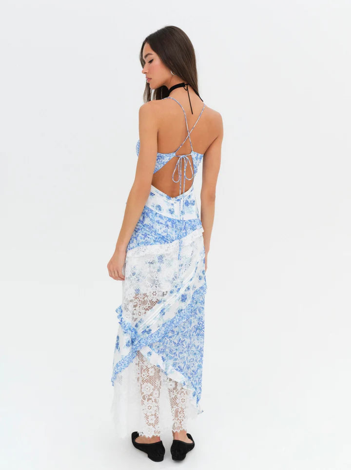 Introducing the luxurious Rosalyn Dress from For Love and Lemons, back in a stunning blue floral print. Inspired by '70s fashion, this maxi dress features mixed print paneling and delicate floral lace with elegant ruffle details. The plunging neckline and skinny shoulder ties add a touch of sophistication. Perfectly fitted through the bust, this dress then cascades into an A-line silhouette, creating a flattering and effortless look. 