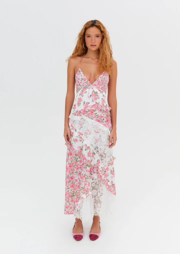 Introducing the luxurious Rosalyn Dress from For Love and Lemons, back in a stunning blue floral print. Inspired by '70s fashion, this maxi dress features mixed print paneling and delicate floral lace with elegant ruffle details. The plunging neckline and skinny shoulder ties add a touch of sophistication. Perfectly fitted through the bust, this dress then cascades into an A-line silhouette, creating a flattering and effortless look. 