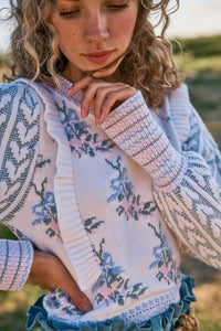 Elevate your style with Warwick in Dew Drop Cream. The romantic floral knit intarsia and framing knit heart jacquard blouson sleeves add a touch of elegance to this cropped crewneck sweater. The striped rib knit neck, cuffs and hem offer a flattering fit and extra detail. Embrace your feminine side with this must-have sweater.