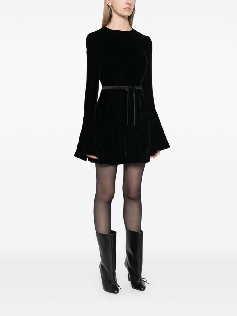 Indulge in opulence with SAINT LAURENT's velour mini dress. The retro-inspired bell sleeves and flared skirt exude a skater vibe, while the open back adds a touch of sensuality. Made in Italy, the plush velour is elevated by a satin belt that cinches your waist. Complete the look with stilettos and a mini bag.