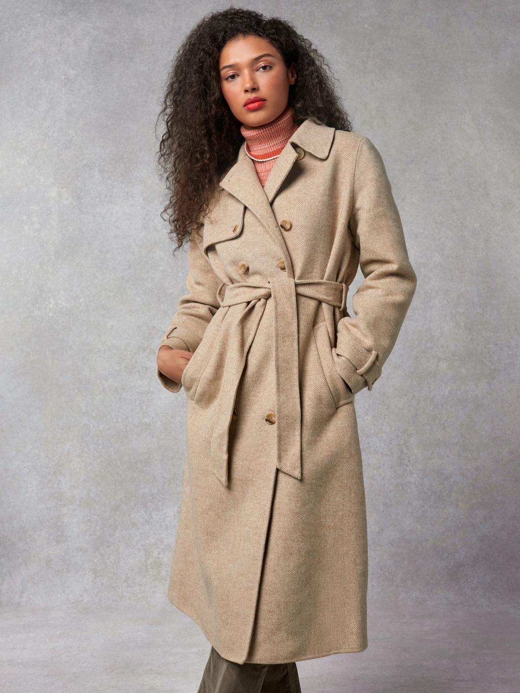 Indulge in luxury with the Manteaux Elisa. This long coat with a classic beige herringbone pattern and a belted waist exudes elegance. The cross-over collar, button details on the cuffs, and back slit add sophistication. Elevate your style with this statement piece.