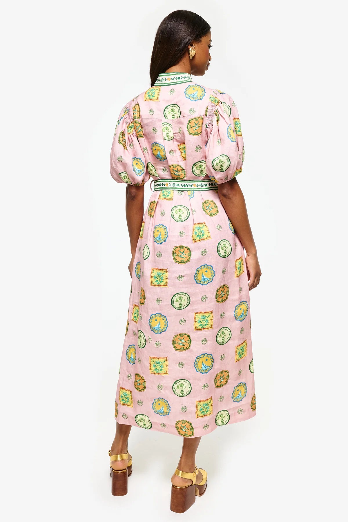 Get ready to turn heads at your next summer dinner party with the Porcelain Shirtdress! This delightful pink midi features charming green and yellow accents and a fitted silhouette with elasticated balloon sleeves. The elegant shell buttons, in-seam pockets, and self-tie belt add practicality and playful details. Elevate your summer style with the Porcelain Shirtdress.