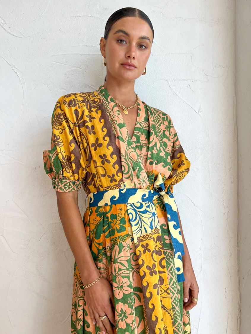 A tropical delight, ALÈMAIS welcomes the Archie Wrap Dress in Multi.   Crafted from a linen fabrication, this relaxed wrap dress silhouette features tuck details at the waist, elasticated cuff and self tie.   Falling to a flared skirt, it is the perfect companion for long lunches, beach days and weekend wanderings.