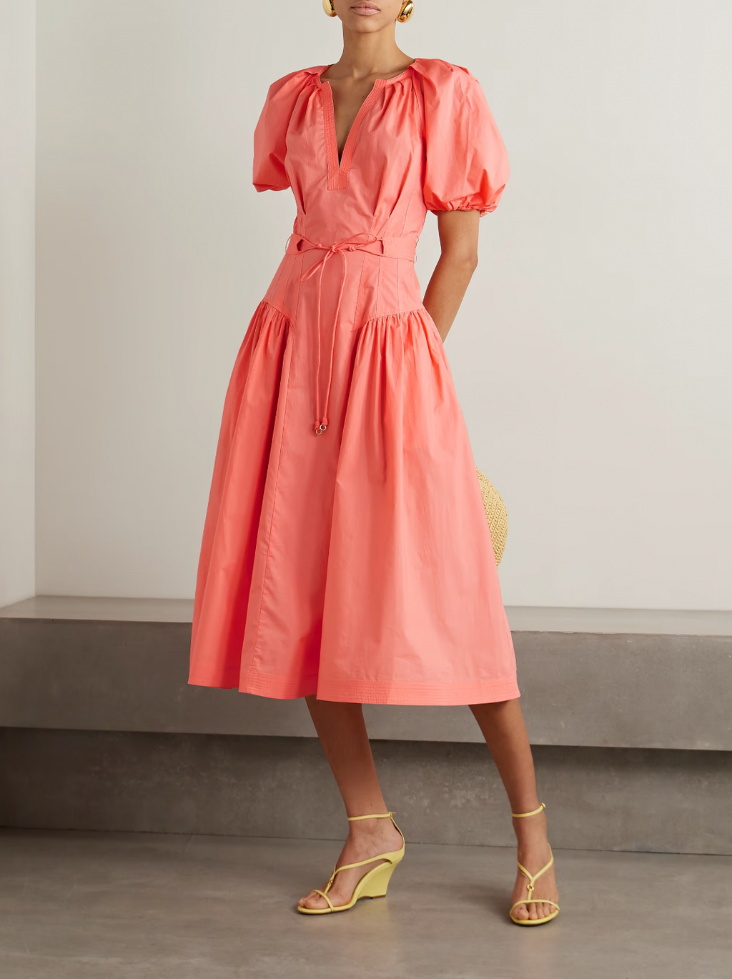 Elevate your summer wardrobe with the Carina Poplin Midi Dress from Ulla Johnson. Crafted from lightweight cotton-poplin, this vibrant coral dress features strategic pleats and a self-tie belt to cinch your waist. The puffed sleeves and gathered panels add a touch of volume, making it perfect for any event.