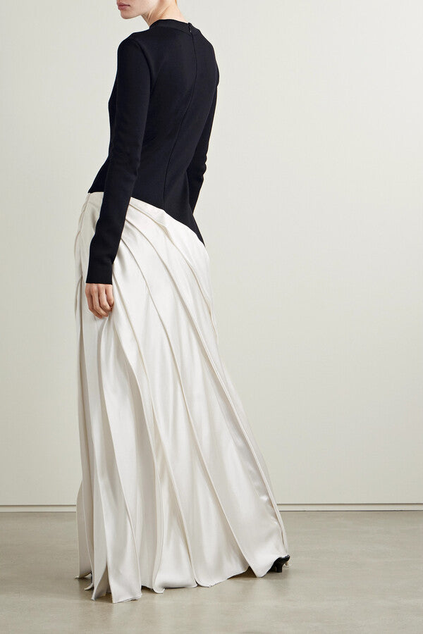 Indulge in luxury with the Ismay Silk Pleated Maxi Dress by Gabriela Hearst. This elegantly crafted piece boasts a clever design, featuring a black silk knitted bodice and a white pleated satin skirt for a striking contrast. The sharp pleats create beautiful movement as you walk, while the mock neckline adds a touch of sophistication. Perfectly paired with classic pumps for a timeless look.