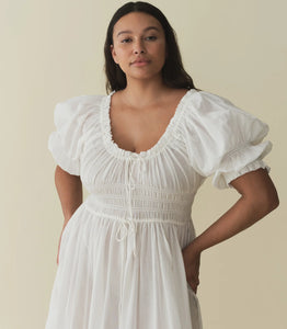 In a soft, lightweight blend of organic cotton and viscose, our beloved Ischia Dress—a Favorite Character that first made its debut in Spring 2021—features double-puffed sleeves and a scoop neckline adorned with petite ruffles and a functional center tie. A smocked bodice with an adjustable waist tie gives way to an ankle-grazing A-line skirt.