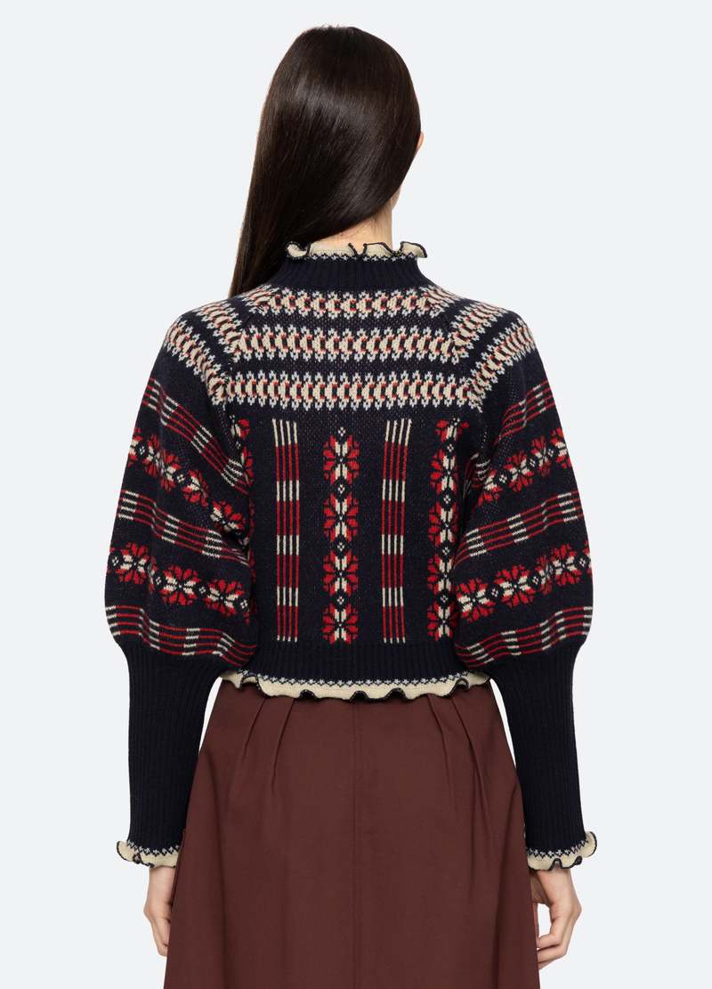 The Ayla Cardigan by SEA has a beautiful fair isle knit pattern and long puff sleeves, making it a stylish addition to any wardrobe. The exposed front zipper allows for easy on and off, while the ruffle detailing adds a touch of femininity. Made of 100% wool, this cardigan is designed for a comfortable and relaxed fit.