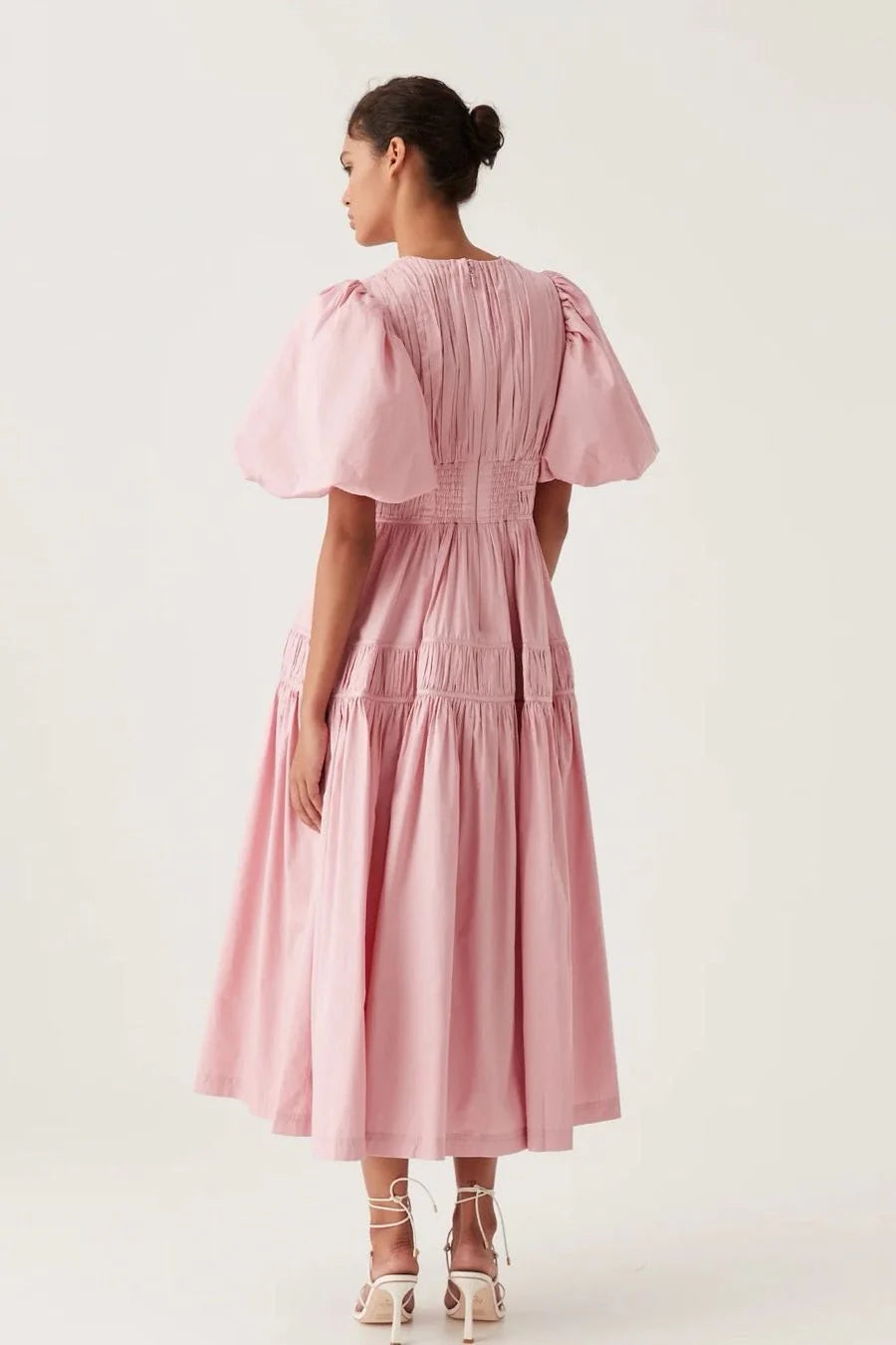 Elevate your special occasion look with the Fallingwater Ruched Midi Dress by AJE. Made from sweet 'Chalk Pink' cotton-poplin, this dress boasts a romantic and playful silhouette with voluminous puffed sleeves and a cinched waist. Rent now to make a stand-out statement!