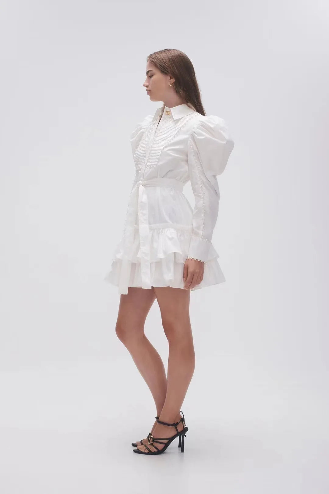 Introducing Dress Paula - a versatile and stylish addition to your wardrobe. This mini shirt dress features a lotus leaf pendulum and decorative layered design, creating a slim waist and flattering silhouette. Made with soft cotton and long bubble sleeves, it also boasts a delicate pearl edge for added elegance. Perfect for any occasion, let Dress Paula elevate your fashion game.