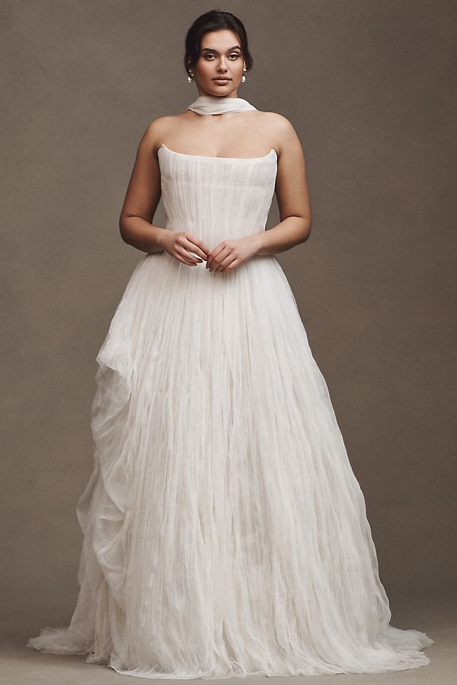 Elevate your wedding day look with the Klelia Gown. Its soft netting, Georgian-style corsetry, and delicate tucks exude both romance and structure. Contemporary style meets timeless charm in the ballgown silhouette, while modern design sensibilities add a touch of uniqueness. Make a statement on your special day with this reimagined classic.