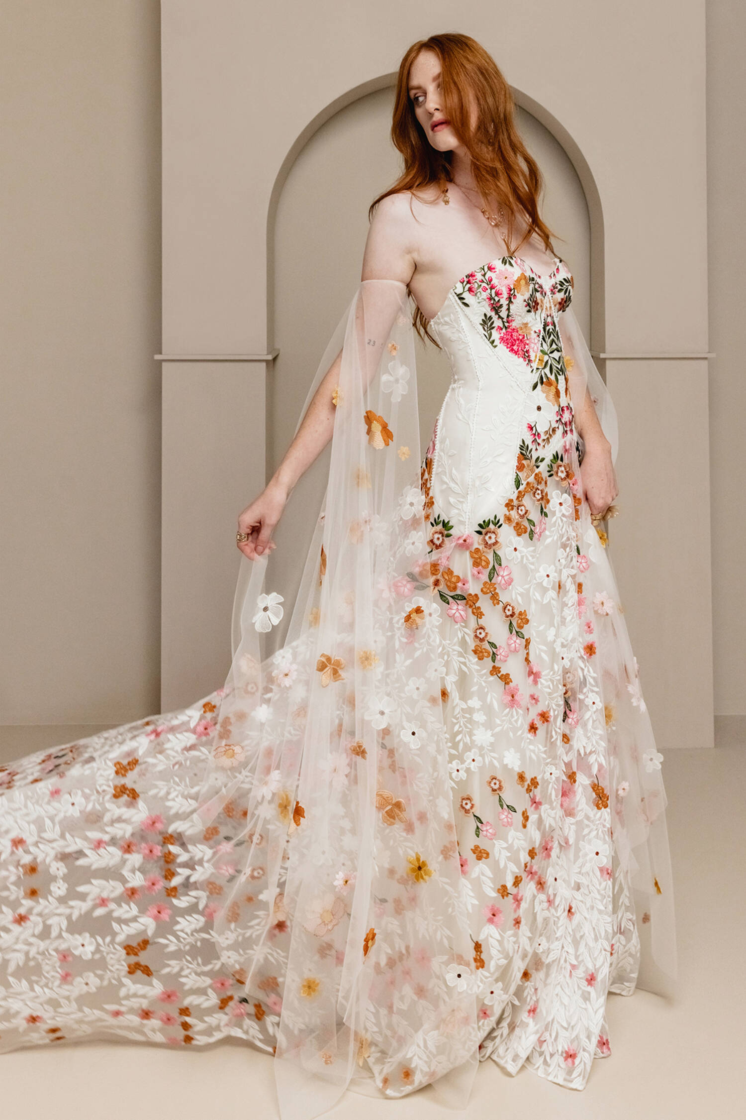 Introducing Meadow Gown - a work of art inspired by desert blooms. Its vibrant florals are delicately embroidered on sand-dyed tulle, creating a stunning contrast against bare terrain. With a fully boned bodice for support and a dramatic train with cascading flowers, this gown exudes a playful yet sophisticated charm. Perfect for the bold bride looking to infuse color into her special day.