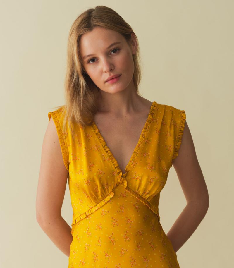 Indulge in luxury with the Tahlia Dress. Made from stunning silk-satin, this ‘30s-inspired dress exudes elegance with its plunging V-neckline, surplice back, and delicate ruffle trim. The adjustable back waist tie ensures a perfect fit, while the snap closure adds a touch of versatility. Perfect for any occasion.