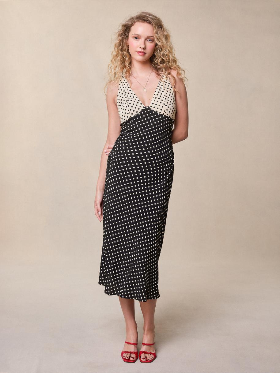 Indulge in the luxurious allure of the Lois Dress. This midi flared dress boasts a sophisticated polka dot print in elegant black and ecru. The heart neckline features a sultry cutout, while the hidden side zip ensures a flawless silhouette. Elevate your wardrobe with this exquisite piece.