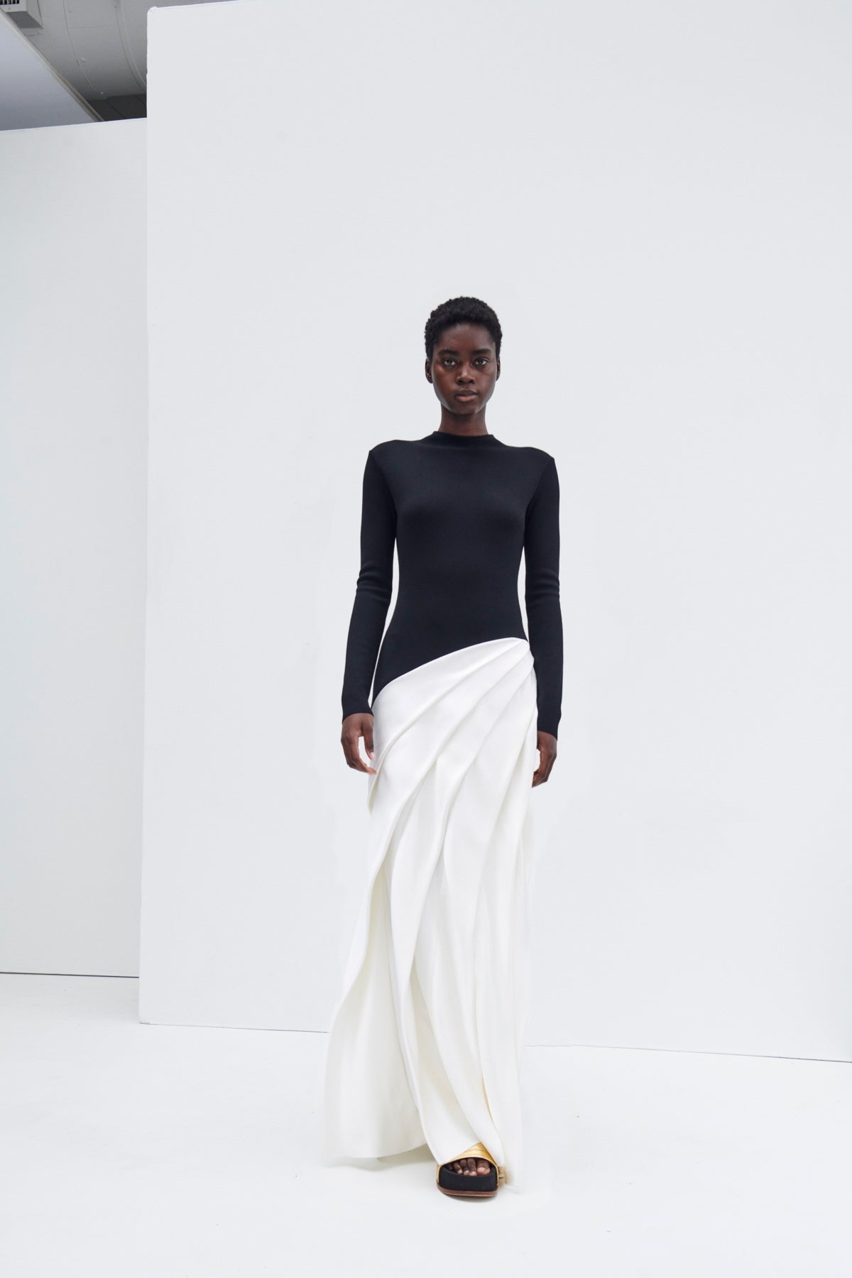 Indulge in luxury with the Ismay Silk Pleated Maxi Dress by Gabriela Hearst. This elegantly crafted piece boasts a clever design, featuring a black silk knitted bodice and a white pleated satin skirt for a striking contrast. The sharp pleats create beautiful movement as you walk, while the mock neckline adds a touch of sophistication. Perfectly paired with classic pumps for a timeless look.