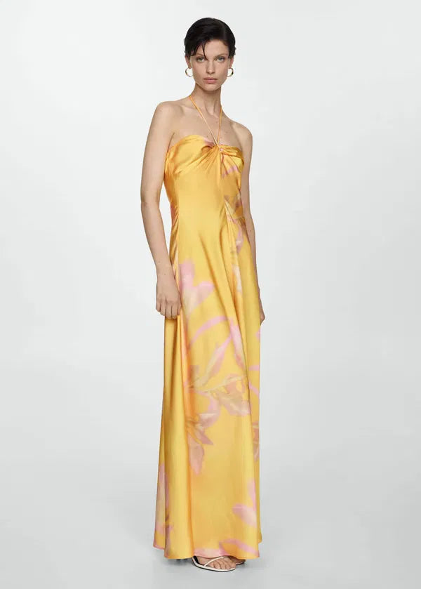 Enhance your elegance with our Printed Satin Dress. The flowy, satin fabric is luxurious and drapes beautifully in the long, straight design. The halter neck and thin straps exude sophistication, while the knot detail adds a touch of artistry. Perfect for any special occasion.