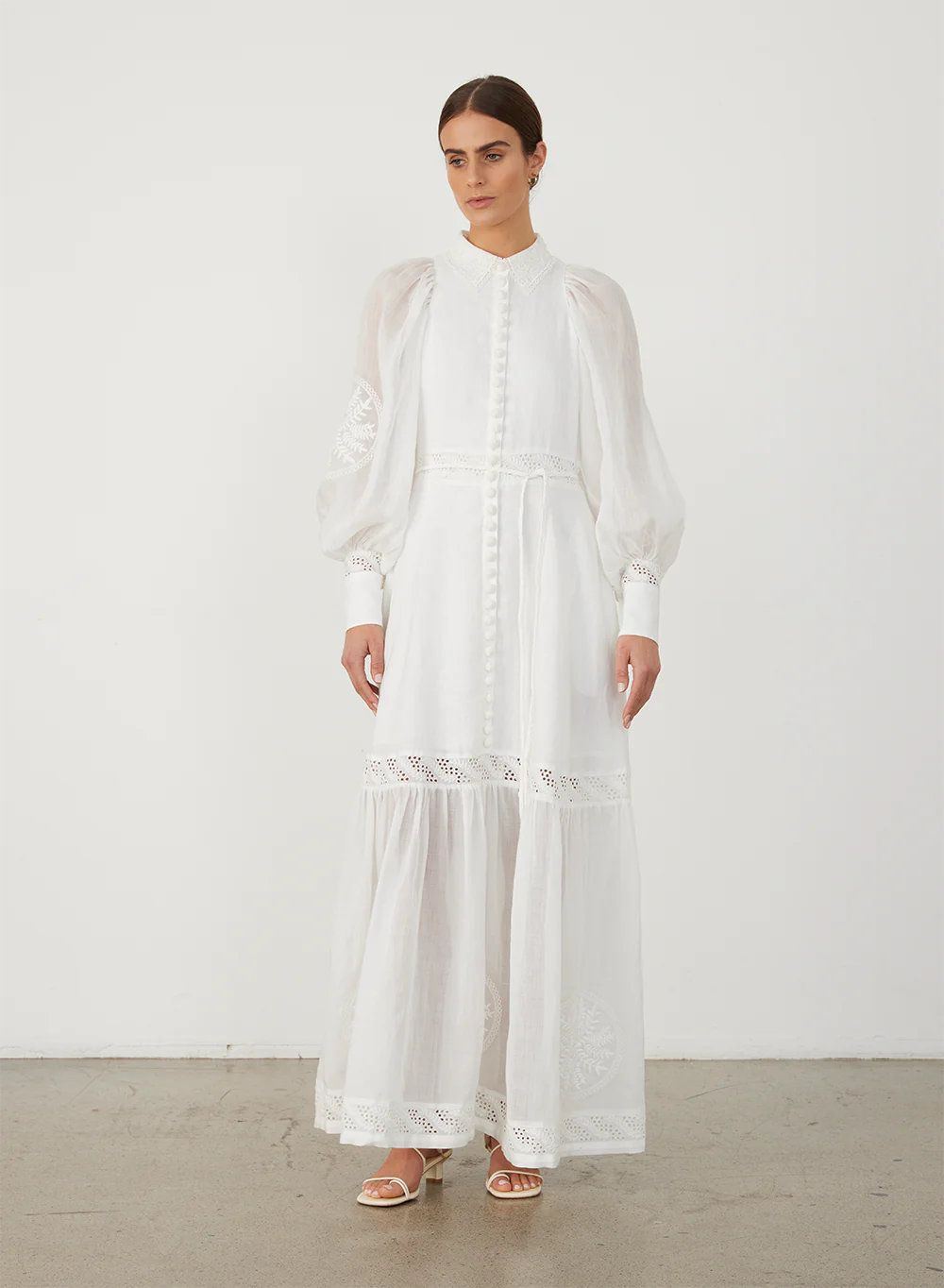 Indulge in timeless elegance with Theodora Maxi Dress by Joslin. Crafted from European Flax Linen, this dress features a classic collar and a shirt fit at the bodice, falling into a full skirt. The stunning ramie organdy sleeves and hem panel add an ethereal touch. Adorned with intricate cotton doilys and crochet buttons for a sophisticated finish.