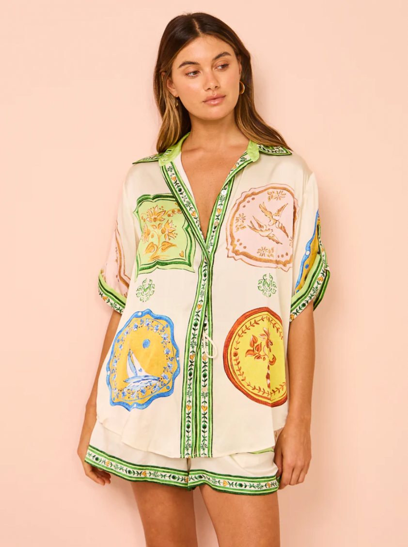 The Paradiso Porcelain Silk Set is perfect for those dreaming of a tropical escape. Crafted from luxurious silk satin, this set includes a shirt with a point collar, rolled sleeves, and shell buttons, and matching shorts or pants. Add a relaxed touch to your beach to bar look with its stunning print.