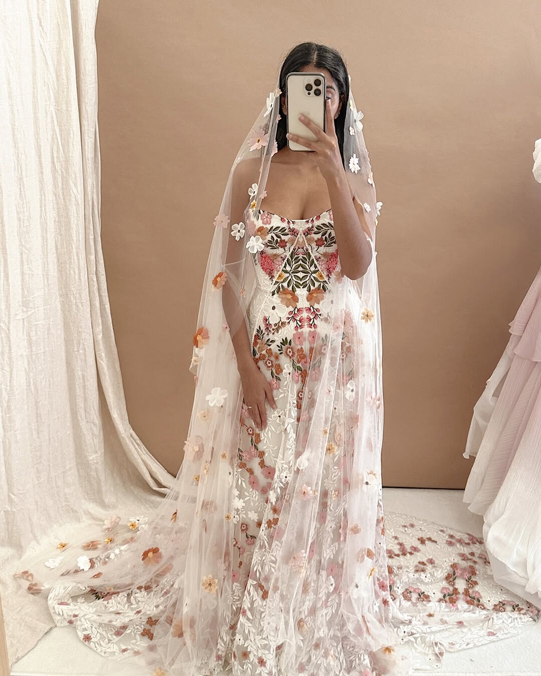 Introducing Meadow Gown - a work of art inspired by desert blooms. Its vibrant florals are delicately embroidered on sand-dyed tulle, creating a stunning contrast against bare terrain. With a fully boned bodice for support and a dramatic train with cascading flowers, this gown exudes a playful yet sophisticated charm. Perfect for the bold bride looking to infuse color into her special day.