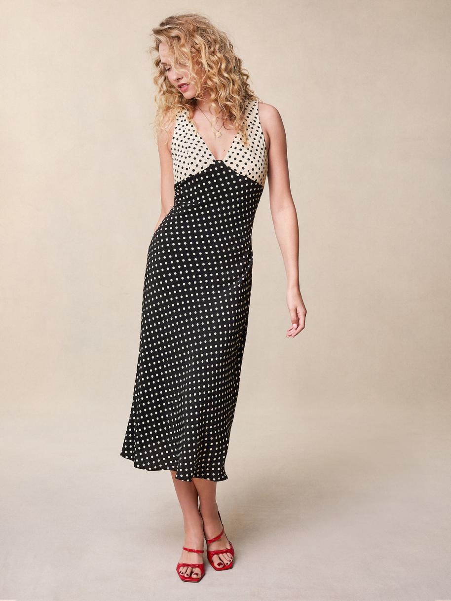 Indulge in the luxurious allure of the Lois Dress. This midi flared dress boasts a sophisticated polka dot print in elegant black and ecru. The heart neckline features a sultry cutout, while the hidden side zip ensures a flawless silhouette. Elevate your wardrobe with this exquisite piece.