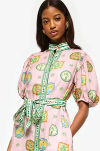 Get ready to turn heads at your next summer dinner party with the Porcelain Shirtdress! This delightful pink midi features charming green and yellow accents and a fitted silhouette with elasticated balloon sleeves. The elegant shell buttons, in-seam pockets, and self-tie belt add practicality and playful details. Elevate your summer style with the Porcelain Shirtdress.