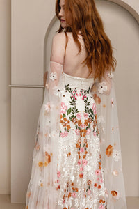 Introducing Meadow Gown - a work of art inspired by desert blooms. Its vibrant florals are delicately embroidered on sand-dyed tulle, creating a stunning contrast against bare terrain. With a fully boned bodice for support and a dramatic train with cascading flowers, this gown exudes a playful yet sophisticated charm. Perfect for the bold bride looking to infuse color into her special day.