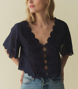 The Kacy Top by DOEN blends vintage charm with modern elegance. Crafted in 100% organic cotton voile, this blouse features charming cutouts, delicate bow embroidery, and breezy elbow-length sleeves. With scalloped details and delicate dot embroidery, this top is a playful yet sophisticated addition to your wardrobe.