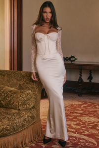 Indulge in timeless elegance with Perdi Maxi Dress. This exquisite satin gown features a corseted bodice with delicate lace cups for a stunning silhouette. The enchanting lace sleeves and intricately designed corset back add a whimsical touch and perfect fit. With a daring back split, this dress effortlessly balances grace and boldness.