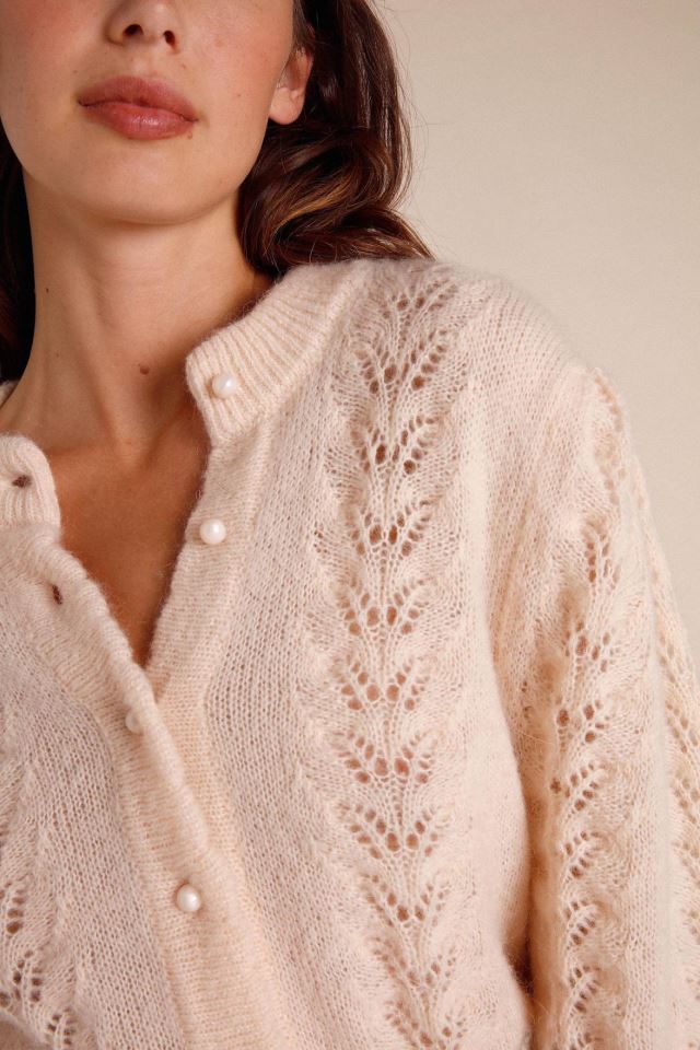 Indulge in the luxury of our Maddy cardigan. This intricately knitted piece features a delicate lace design, a round neckline, and long sleeves. The scalloped edges add a touch of elegance to the button details. Stay stylish and cozy with this must-have addition to your wardrobe.