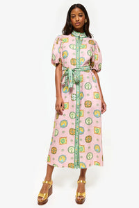 Get ready to turn heads at your next summer dinner party with the Porcelain Shirtdress! This delightful pink midi features charming green and yellow accents and a fitted silhouette with elasticated balloon sleeves. The elegant shell buttons, in-seam pockets, and self-tie belt add practicality and playful details. Elevate your summer style with the Porcelain Shirtdress.